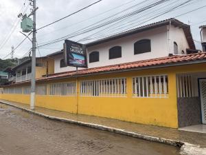 a yellow and white building on the side of a street at Apartamento com sala e cozinha no morro da saudade in Morro de São Paulo