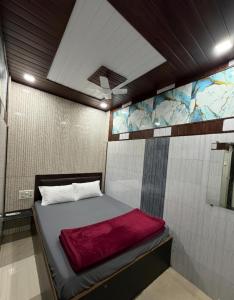 a small room with a bed in a room with a wall at Hotel Al Mehraj in Mumbai