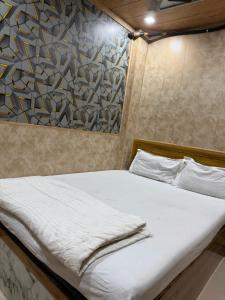 a bed in a room with a painting on the wall at Hotel Al Mehraj in Mumbai