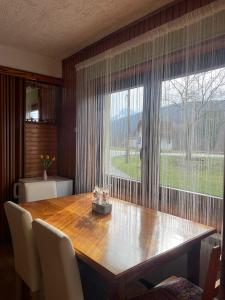 a dining room with a wooden table and a large window at Sokol in Ogulin