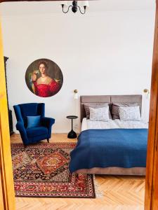 a bedroom with a blue bed and a blue chair at Apartament Rynek 20 in Krosno +60 photos