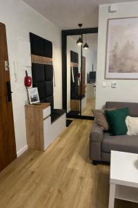 a living room with a couch and a table at Apartament w Centrum z wanną z hydromasażem in Kętrzyn