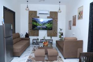 a living room with a couch and a tv on the wall at Nesara the nature villa in Jāmb