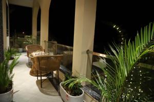 a balcony with chairs and potted plants at night at Nesara the nature villa in Jāmb