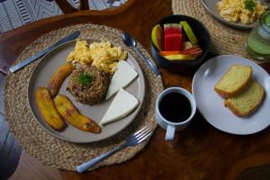 a table with a plate of food with bread and fruit at Conga Boutique Hotel in Puerto Viejo