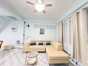 a living room with a couch and a ceiling fan at S Home Hat Yai - Entire House, Private Parking in Hat Yai