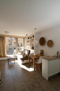 a kitchen and living room with a table and a couch at La Casa dels Abeuradors in Gandesa