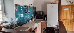 a kitchen with blue tile on the wall and a sink at Il Nido Nel Bosco in Motta