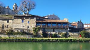 ein altes Steingebäude neben einem Gewässer in der Unterkunft Le Sed' in Nérac