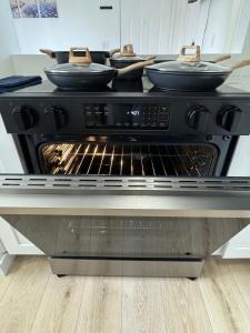 an oven with four pans on top of it at Cozy blue house in Salt Lake City