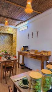 a dining room with tables and a stone wall at Japaratinga Suites in Japaratinga
