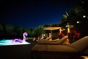 a swimming pool with a pink swan and lounge chairs at Luxe villa for 8 - Heated Pool -AC -BBQ Area - Patio - 160Mbps - Olives - Palm - vineyard in Santa Luzia +20 photos