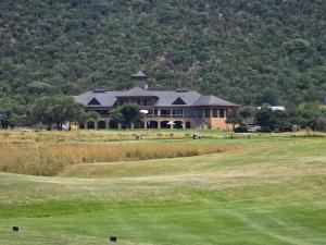 a large house on a golf course with a green at Batau Villa in Naboomspruit
