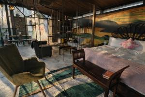 a bedroom with a bed and a chair and a painting at heart & ponie - Retiro Rural Privado con Piscinas in Chinchón +59 photos