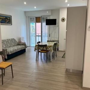 a living room with a table and chairs and a couch at Casa di Leo in Loano
