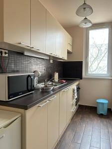 a kitchen with white cabinets and a microwave at Szántó Prime Residence in Szolnok