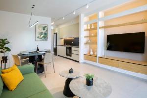 a living room with a green couch and a television at Elysian Luxury Suite in Preveza