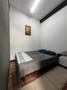 a bedroom with a bed with a picture on the wall at Praia dos Sonhos - Suítes in Itanhaém +10 photos