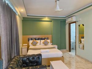 a hotel room with two beds and a couch at Hotel Cozzy Inn in Bangalore