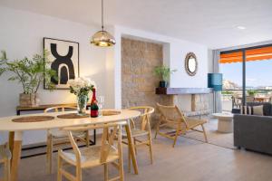 a dining room and living room with a table and chairs at Nogalera Sea View Luxe in Torremolinos