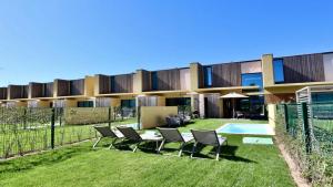 a building with chairs and a table in the yard at Villa Rimah, Sunny Algarve, Entire Villa "heated" pool, Golf, walk to Beaches & Long Stays by Clever Details in Vilamoura