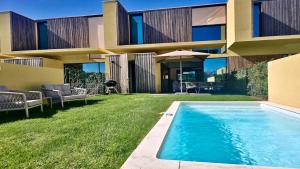 a house with a swimming pool in the yard at Villa Rimah, Sunny Algarve, Entire Villa "heated" pool, Golf, walk to Beaches & Long Stays by Clever Details in Vilamoura