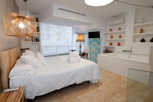 a bedroom with a white bed and a bath tub at La Casa dels Abeuradors in Gandesa