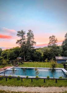 a swimming pool in a yard with a fence at Wincarayen Lodge & Cabañas in Panguipulli