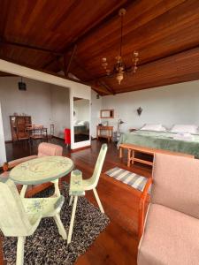 a bedroom with a bed and a table and chairs at Chalé da Mata Lavras Novas in Lavras Novas +62 photos