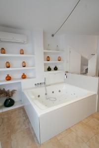 a white bath tub in a room with shelves at La Casa dels Abeuradors in Gandesa +127 photos