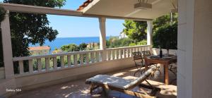 a balcony with a table and chairs and the ocean at Apartmani Dolac in Ivan Dolac