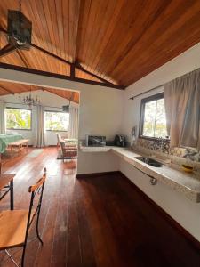 a kitchen and living room with a wooden ceiling at Chalé da Mata Lavras Novas in Lavras Novas