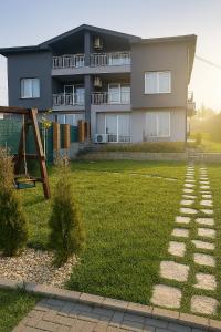 a apartment building with a yard with a playground at Къща за гости Касида in Sapareva Banya