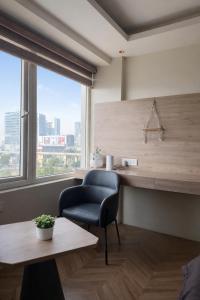 a office with a chair and a table and a window at Luna Stays in Greater Noida