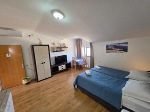 a bedroom with a blue bed and a television at Tonino Apartment in Pag