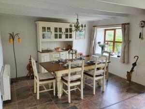 a dining room with a wooden table and chairs at An Cnocan in Sneem
