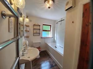 a bathroom with a sink and a tub and a toilet at An Cnocan in Sneem