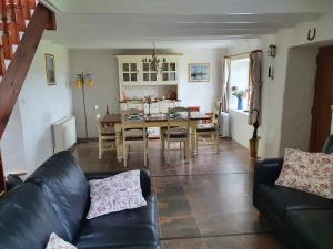 a living room with a black leather couch and a table at An Cnocan in Sneem +43 photos