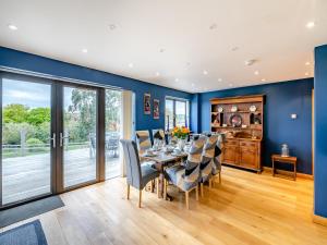 a dining room with blue walls and a table with chairs at Highfields in Runswick +37 photos