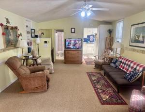 a living room with a couch and a tv at The Wellington Lake Cottage in Middlebury