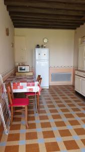 a kitchen with a table and a white refrigerator at Gite à Lulu in Châteauvieux