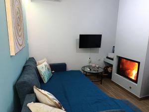 a living room with a blue couch and a tv at Charavgi House in Archangelos