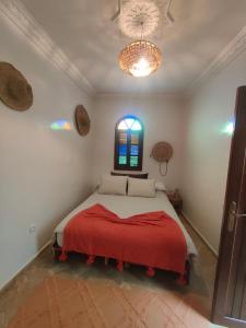 a bedroom with a bed with a red blanket and a window at Riad Privé Bkl luxury Dar Baroud in Tangier +11 photos