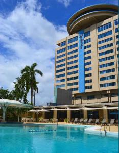 a hotel with a swimming pool in front of a building at Radisson Hotel Trinidad in Port-of-Spain