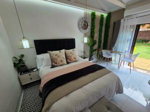 a bedroom with a large bed and a patio at Indulge Deluxe Accommodation in Middelburg