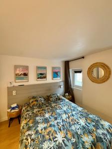 a bedroom with a bed with a floral bedspread at Chez Audrey & Bastien in Dinan +22 photos