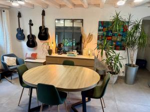 a table and chairs in a room with guitars on the wall at Chez Audrey & Bastien in Dinan