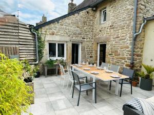 a patio with a table and chairs and a building at Chez Audrey & Bastien in Dinan
