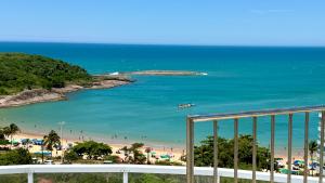 a view of a beach and the ocean from a balcony at Guarapari Bacutia Peracanga an9 in Guarapari