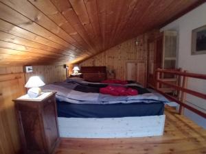 a bed in a room with a wooden ceiling at Il quattordici in Rimasco